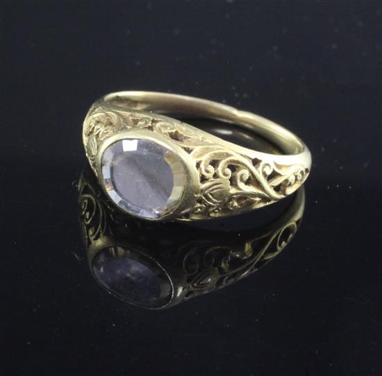 An antique scroll-pierced yellow metal ring set with an oval diamond,